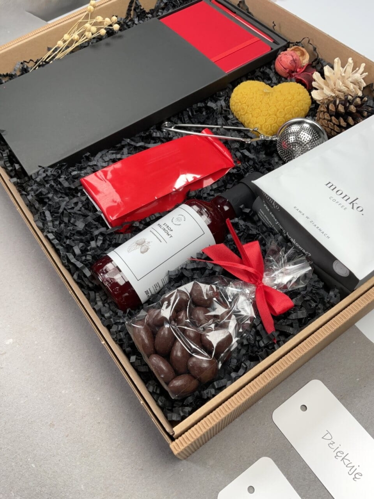 gotowy do wręczenia prezent kosz z naturalnymi produktami handmade pachnąca świeca z naturalnego wosku pszczelego migdały w delikatnej czekoladzie deserowej aromatyczna kawa świeżo palona syrop malinowy do herbaty