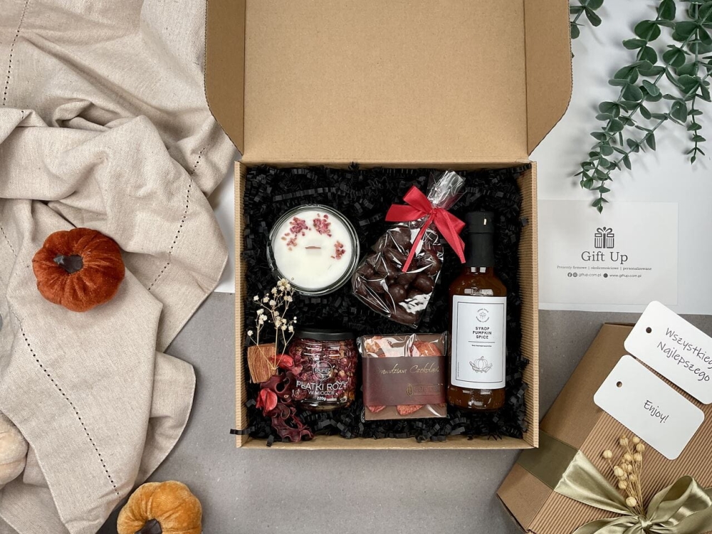 jesienny zestaw prezentowy zapakowany gotowy do wręczenia ze świecą sojową ręcznie robioną syropem dyniowym pumpkin spice do kawy i pięknymi płatkami róży w miodzie, chrupiącymi migdałami w czekoladzie deserowej