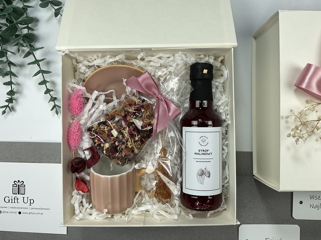 zapakowany prezent gotowy do wręczenia box zawiera pyszną mocno owocową herbatę, przepiękną jasno różową filiżankę naturalny syrop malinowy mieszadełko cukrowe wszystko zapakowane i gotowe do wręczenia