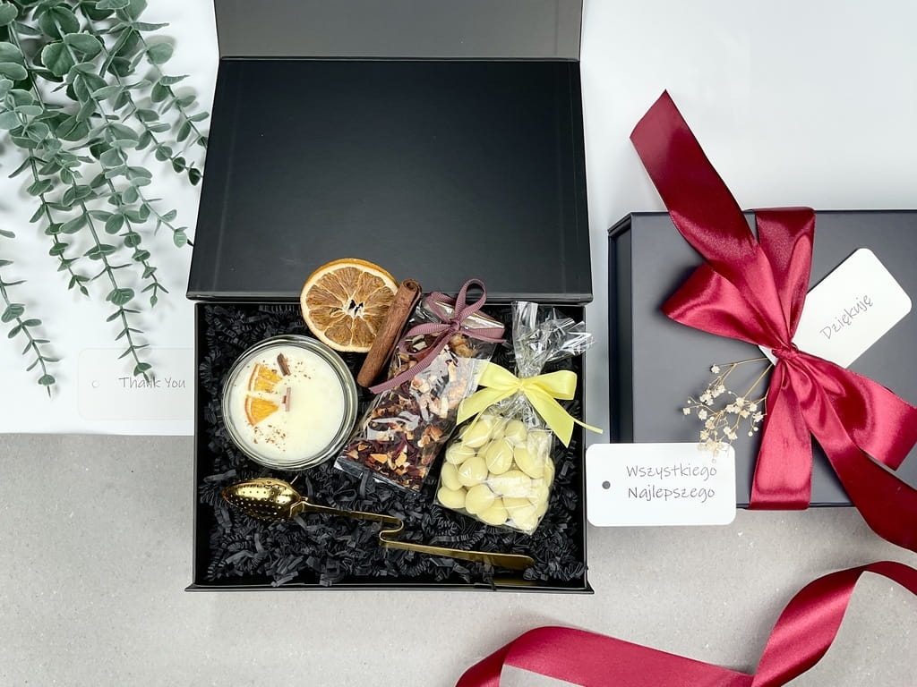 stylowy elegancki zestaw prezentowy pudełko magnetyczne satynowa kokarda a w środku stylowy złoty zaparzacz do herbaty homla, słodkie migdały w białej czekoladzie owocowa herbata z pomarańczą i hibiskusem zapachowa świeca sojowa