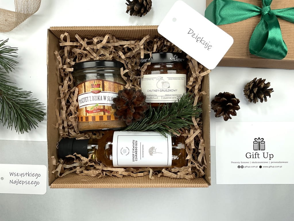 prezent zestaw box firmowy upominkowy z pasztetem z dzika w słoiku, z chutney gruszkowym, syropem z kwiatów z czarnego bzu. Pudełko tekturowe z wiórkami papierowymi zapakowane gotowe do wręczenia