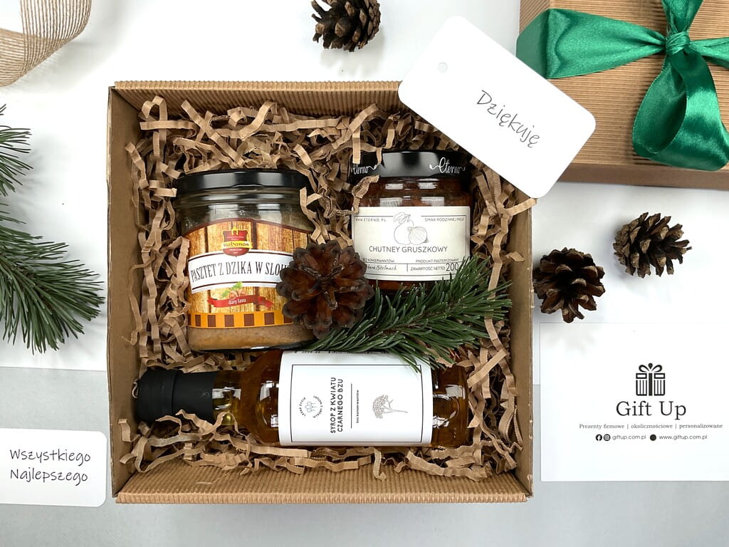 prezent zestaw box firmowy upominkowy z pasztetem z dzika w słoiku, z chutney gruszkowym, syropem z kwiatów z czarnego bzu. Pudełko tekturowe z wiórkami papierowymi zapakowane gotowe do wręczenia