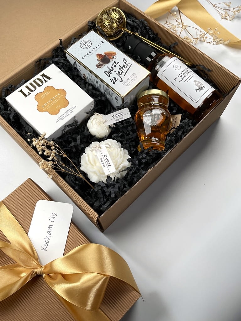 gotowy zestaw box prezentowy firmowy na urodziny imieniny a w nim herbata kwiatowa, migdały w ciemnej belgijskiej czekoladzie złoty zaparzacz do herbaty świece sojowe kwiat piwonii syrop waniliowy bourbon