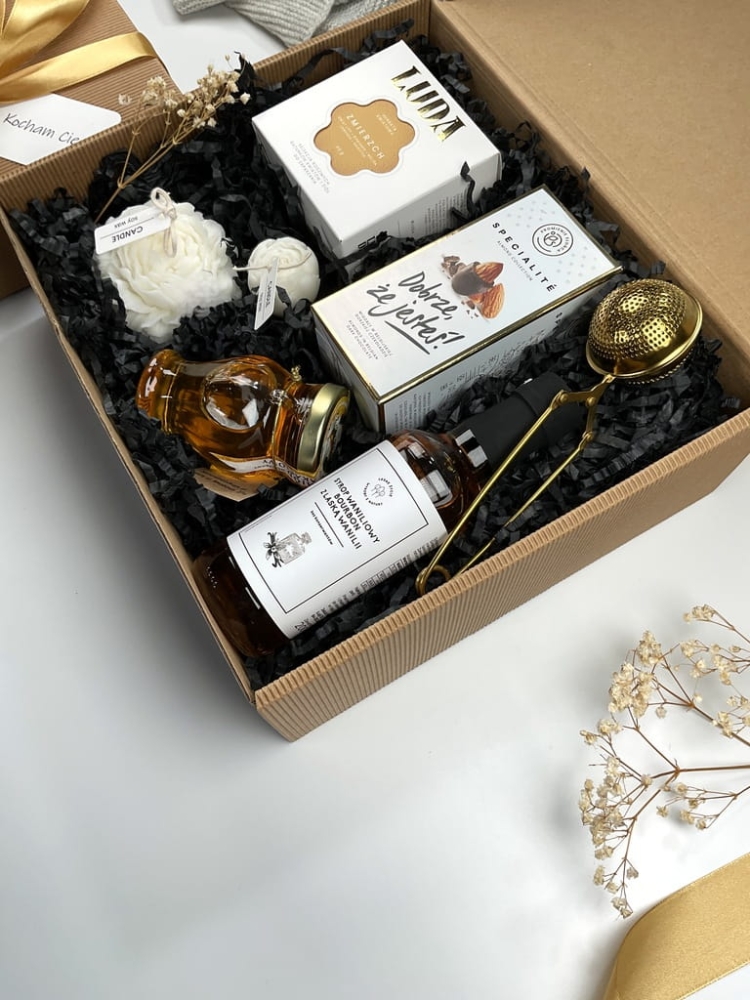 zestaw box prezentowy złoty na urodziny imieniny z przepyszną herbatą kwiatową, naturalnym miodem wielokwiatowym, chrupiącymi migdałami w belgijskiej czekoladzie, zaparzaczem do herbaty i syropem waniliowym, świecą z wosku sojowego w kształcie kwiatu