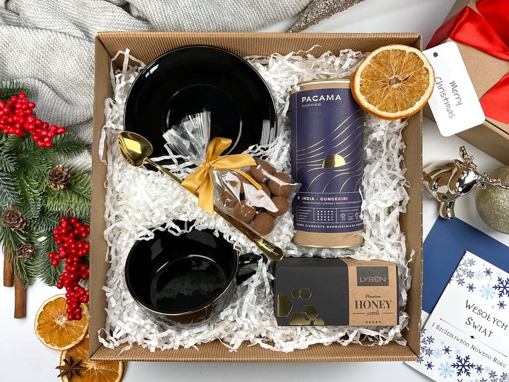 Świąteczny gift box premium z elegancką filiżanką, złotą łyżeczką, kawą ziarnistą, orzechami w mlecznej czekoladzie z cynamonem i krówką miodową. Stylowy prezent na Boże Narodzenie, luksusowy zestaw dla miłośników kawy.