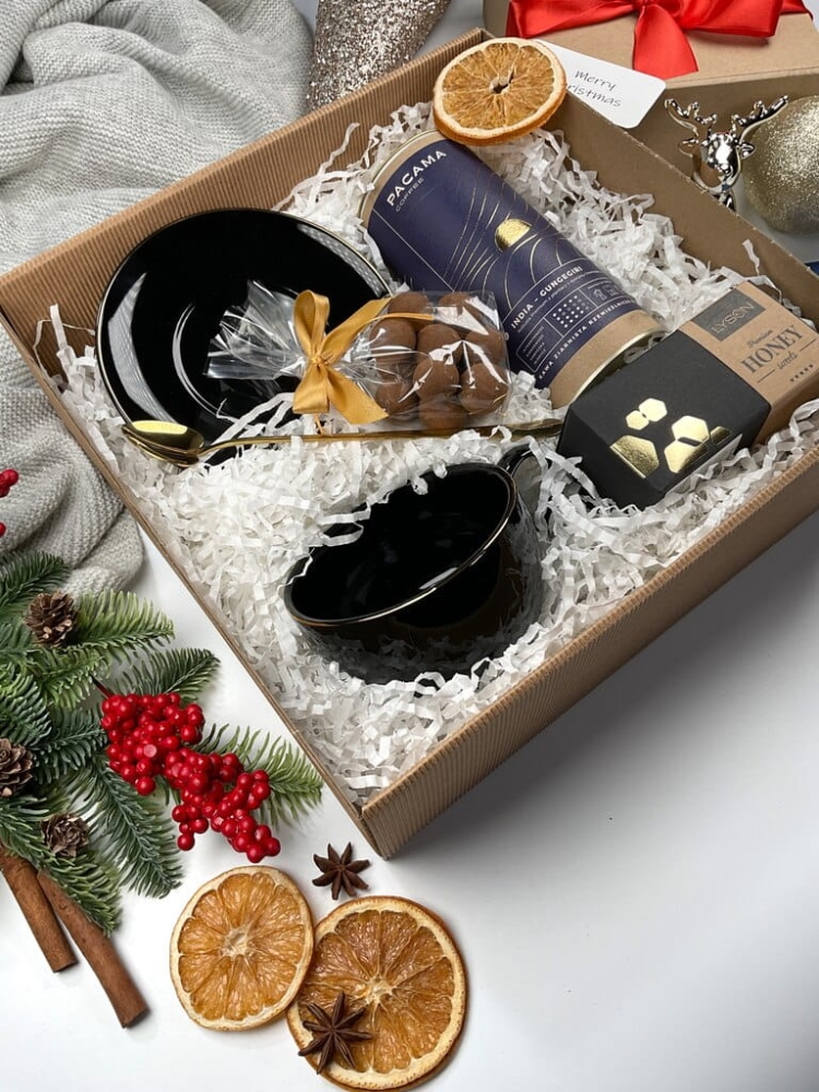 Świąteczny gift box premium z elegancką filiżanką, złotą łyżeczką, kawą ziarnistą, orzechami w mlecznej czekoladzie z cynamonem i krówką miodową. Stylowy prezent na Boże Narodzenie, luksusowy zestaw dla miłośników kawy.
