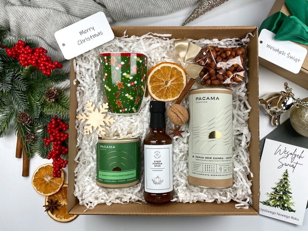 Box świąteczny premium: elegancki porcelanowy kubek świąteczny, kawa ziarnista w metalowej puszce, agrest w czekoladzie, syrop pumpkin spice, orzeszki w karmelu z miodem. Doskonały prezent świąteczny dla bliskich, współpracowników i klientów firmowych.