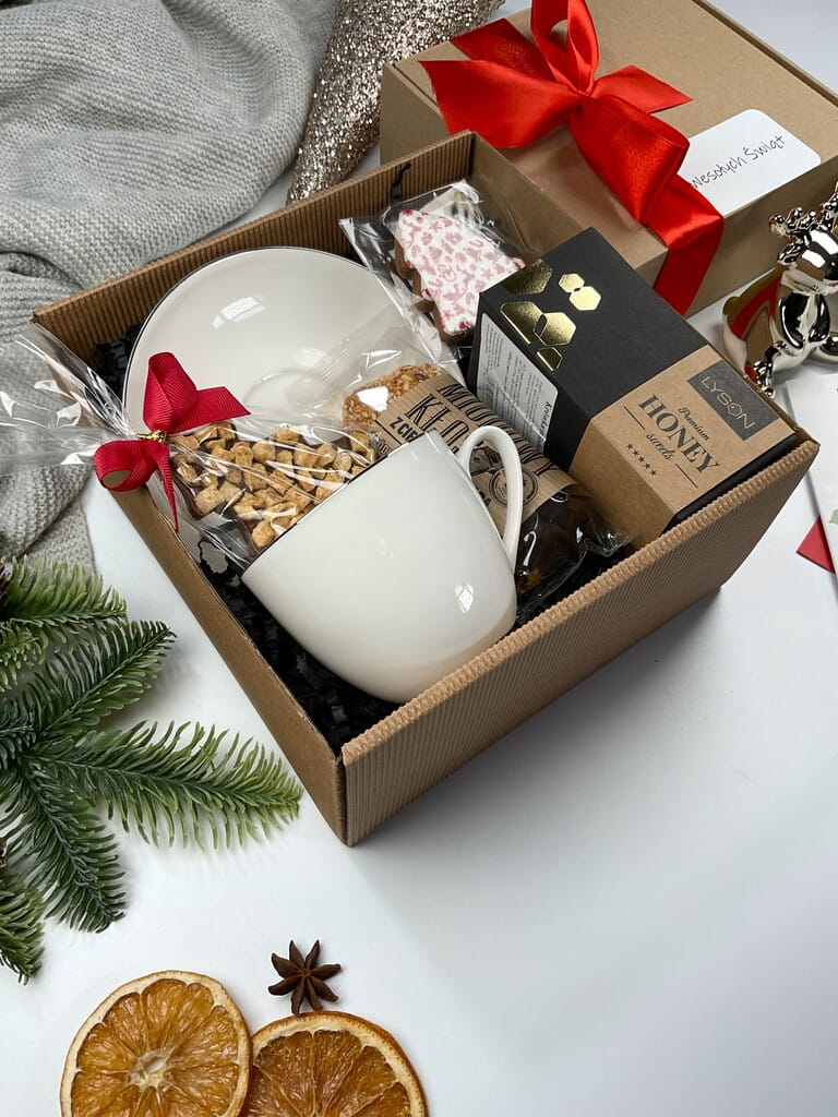 Elegancki prezent świąteczny: biała filiżanka ze srebrnym rantem, czekolada choinka mleczna z jabłkiem i cynamonem, naturalny baton miodowy, krówka miodowa i pierniczek. Upominek pod choinkę.