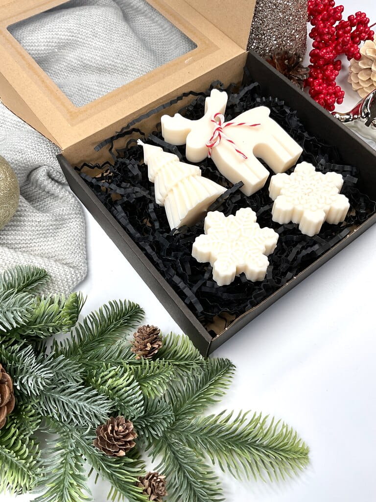 Świąteczny gift box z ręcznie robionymi świecami sojowymi. Cztery dekoracyjne kształty: renifer, śnieżynki, choinka. Idealny prezent, gotowy do wręczenia.