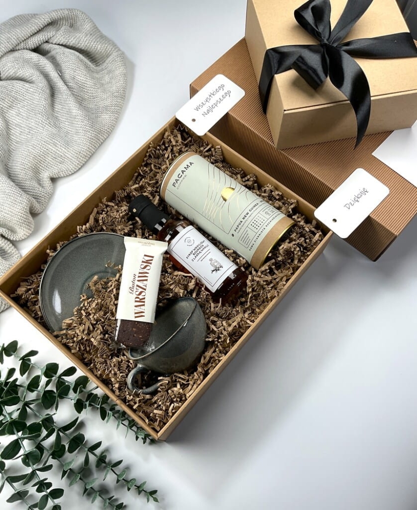 Elegancki gift box z filiżanką z kamionki, kawą premium, syropem waniliowym i batonem bezglutenowym. Idealny prezent świąteczny, biznesowy lub okolicznościowy.