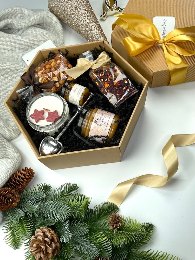 Elegancki zestaw świąteczny w sześciokątnym pudełku z ręcznie robioną świecą sojową, chrupiącymi orzeszkami, konfiturą, herbatą zimową i miodem piernikowym.
