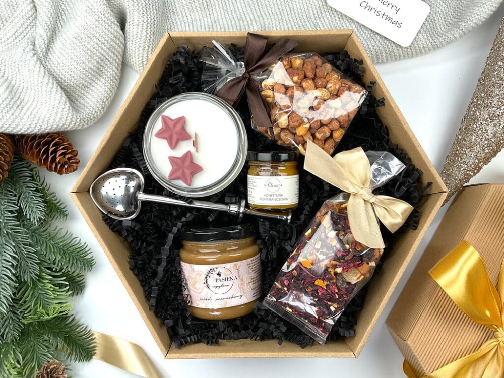 Świąteczny gift box z ręcznie robioną świecą sojową, orzechami karmelizowanymi z miodem, zimową herbatą, miodem piernikowym, konfiturą pomarańczową i dekoracyjnym zaparzaczem serce.