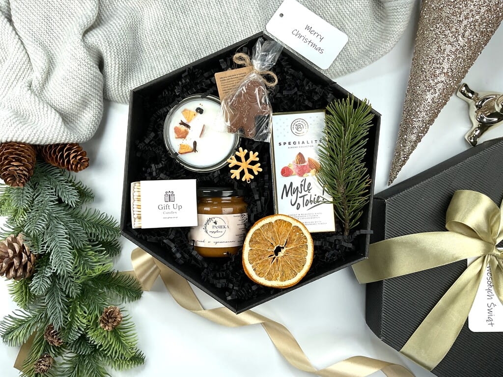 Świąteczny box prezentowy: świeca sojowa pieczone jabłko, czekoladowy ludek, różowe migdały w czekoladzie, miód cynamonowy i eleganckie zapałki.