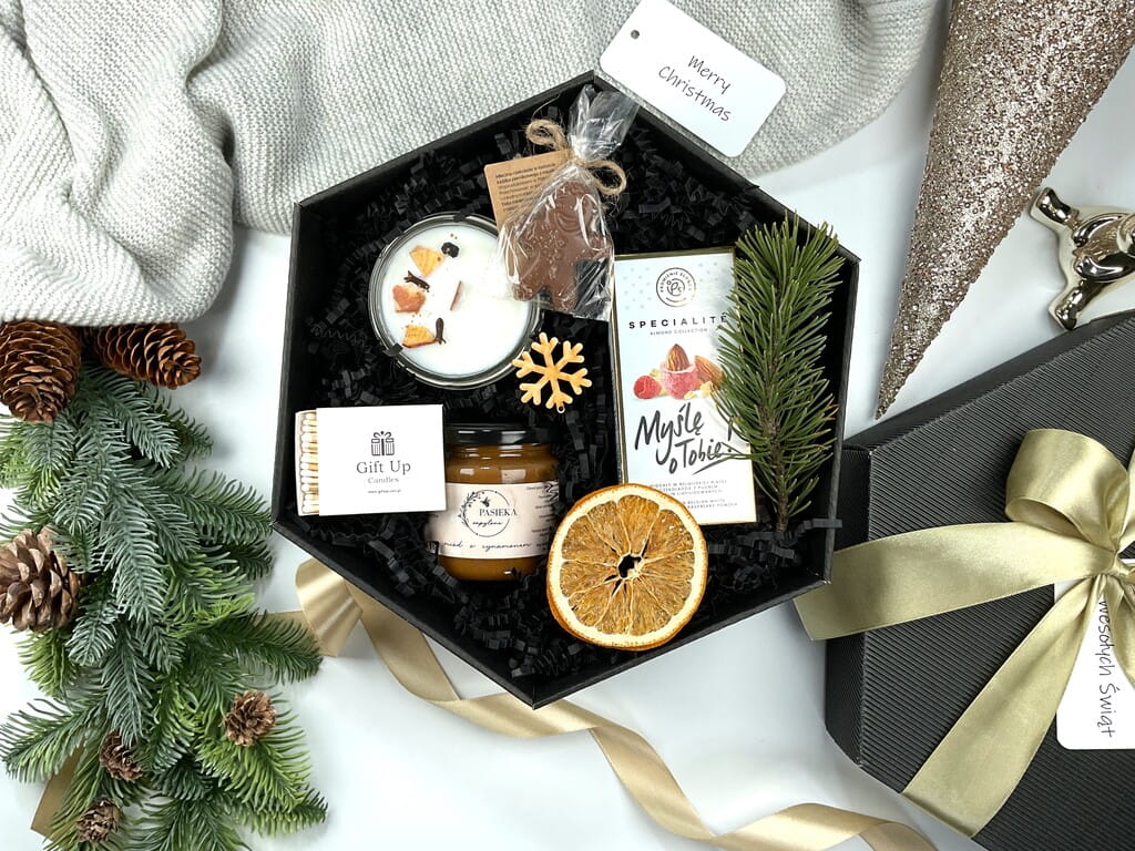 Świąteczny box prezentowy: świeca sojowa pieczone jabłko, czekoladowy ludek, różowe migdały w czekoladzie, miód cynamonowy i eleganckie zapałki.