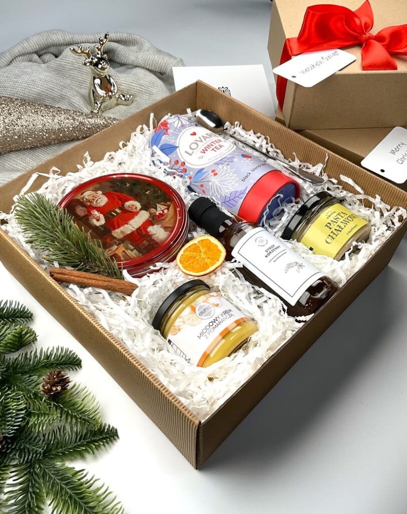 Zimowy zestaw śniadaniowy – elegancki upominek na święta Słodki i aromatyczny box: herbata świąteczna, syrop korzenny, maślane ciasteczka, pasta chałwowa i krem miodowy z pomarańczą. Całość uzupełnia długa srebrna łyżeczka. Gotowy prezent.