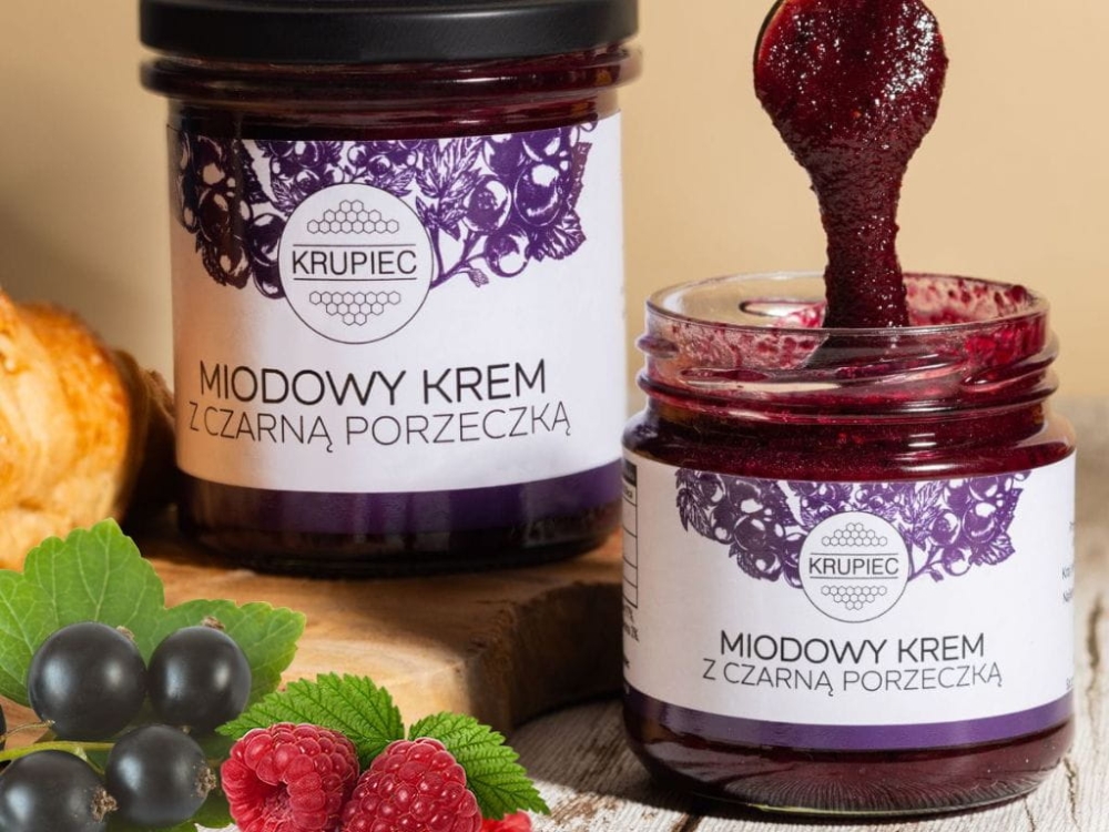 Naturalny miodowy krem z czarną porzeczką. Skład: miód wielokwiatowy 96%, czarna porzeczka liofilizowana 4%. Owocowy, zdrowy krem bez cukru i dodatków.