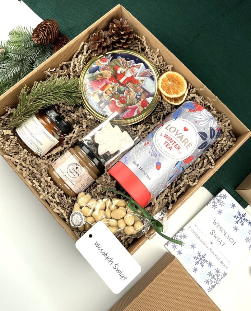Elegancki zestaw świąteczny: maślane ciasteczka, aronia w białej czekoladzie, zimowa herbata, miód piernikowy, cytrynki w syropie, pierniczek lukrowany — idealny pod choinkę.
