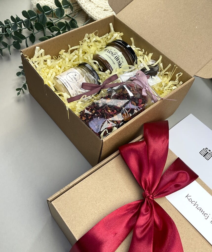 Elegancki box śniadaniowy z kremem śniadaniowym, herbatą owocową, kremowym miodem pomarańczowym i łyżeczką z czekolady. Doskonały prezent dla bliskich.