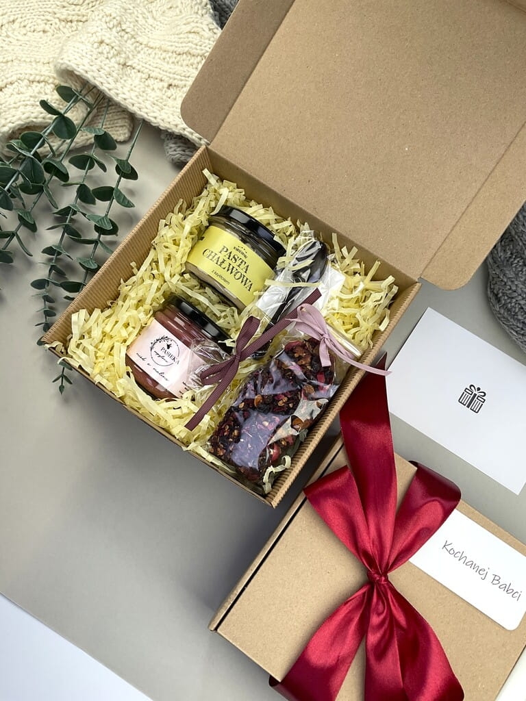 Elegancki box śniadaniowy z kremem chałwowym, herbatą owocową, kremowym miodem malinowym i łyżeczką z czekolady. Doskonały prezent dla bliskich.