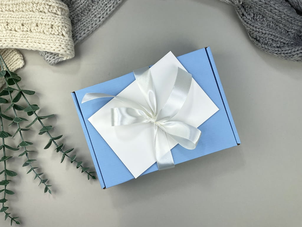 Box niemowlęcy premium: muślinowa pieluszka, grzechotka handmade, zawieszka na smoczek, drewniany element z imieniem oraz kartka z życzeniami. Wyjątkowy prezent dla chłopca.