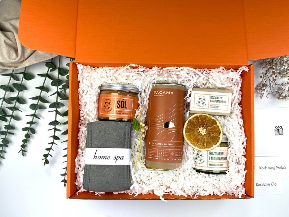 Pomarańczowy zestaw prezentowy z naturalnymi kosmetykami: sól do kąpieli rokitnik i bergamotka, peeling cukrowy rozmaryn–mandarynka, mydełko handmade, opaska spa i kawa premium.