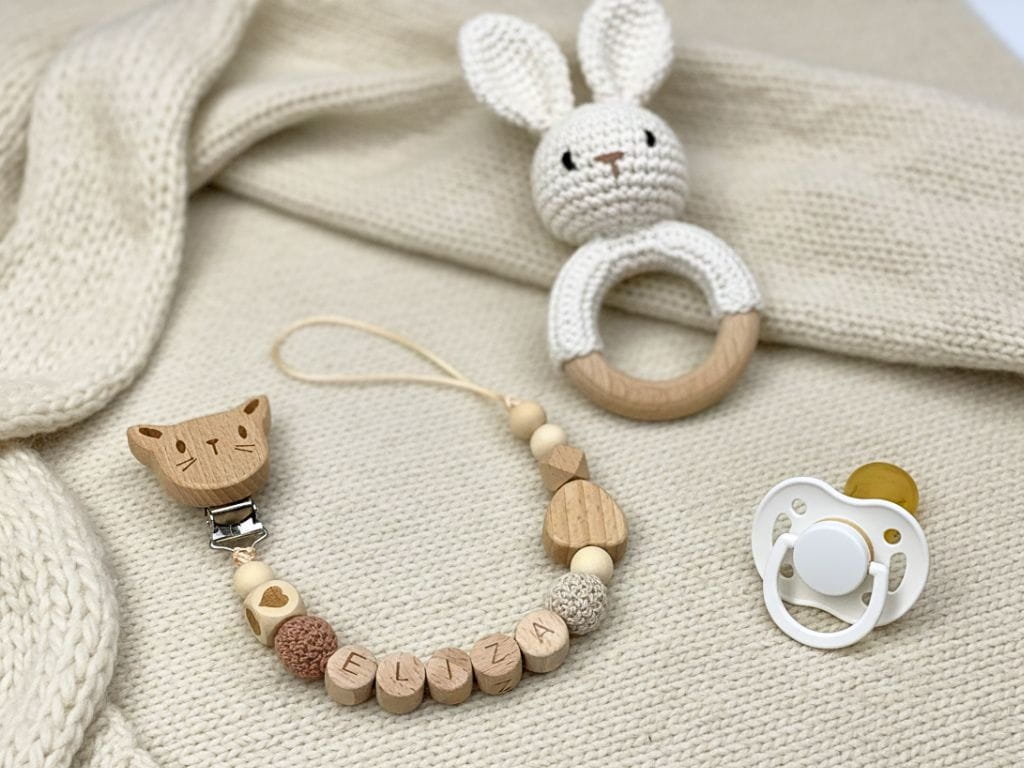 Ręcznie robiona zawieszka do smoczka z imieniem z naturalnego drewna bukowego i świerkowego. Personalizowana, ekologiczna zawieszka z drewnianych koralików, bawełnianej nitki i mocnego sznurka. Idealna na prezent dla dziecka.