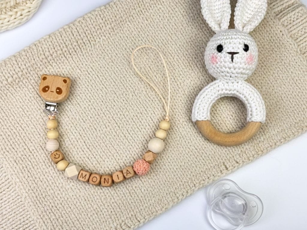 Ręcznie robiona zawieszka do smoczka z imieniem z naturalnego drewna bukowego i świerkowego. Personalizowana, ekologiczna zawieszka z drewnianych koralików, bawełnianej nitki i mocnego sznurka. Idealna na prezent dla dziecka.