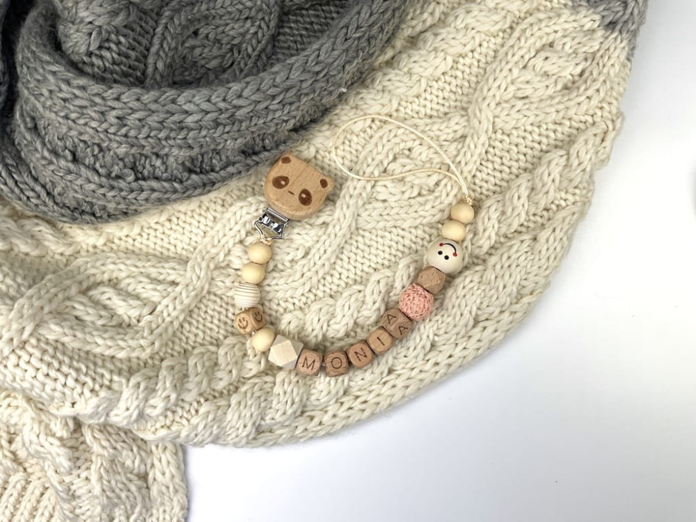 Ręcznie robiona zawieszka do smoczka z imieniem z naturalnego drewna bukowego i świerkowego. Personalizowana, ekologiczna zawieszka z drewnianych koralików, bawełnianej nitki i mocnego sznurka. Idealna na prezent dla dziecka.