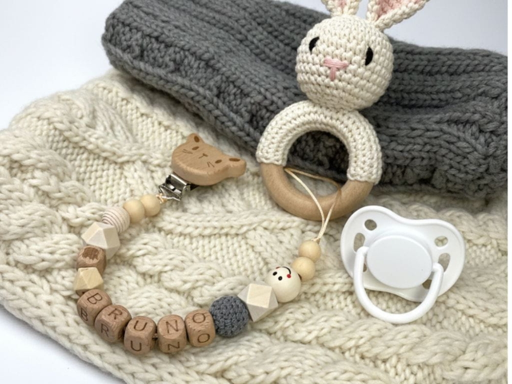 Ręcznie robiona zawieszka do smoczka z imieniem z naturalnego drewna bukowego i świerkowego. Personalizowana, ekologiczna zawieszka z drewnianych koralików, bawełnianej nitki i mocnego sznurka. Idealna na prezent dla dziecka.