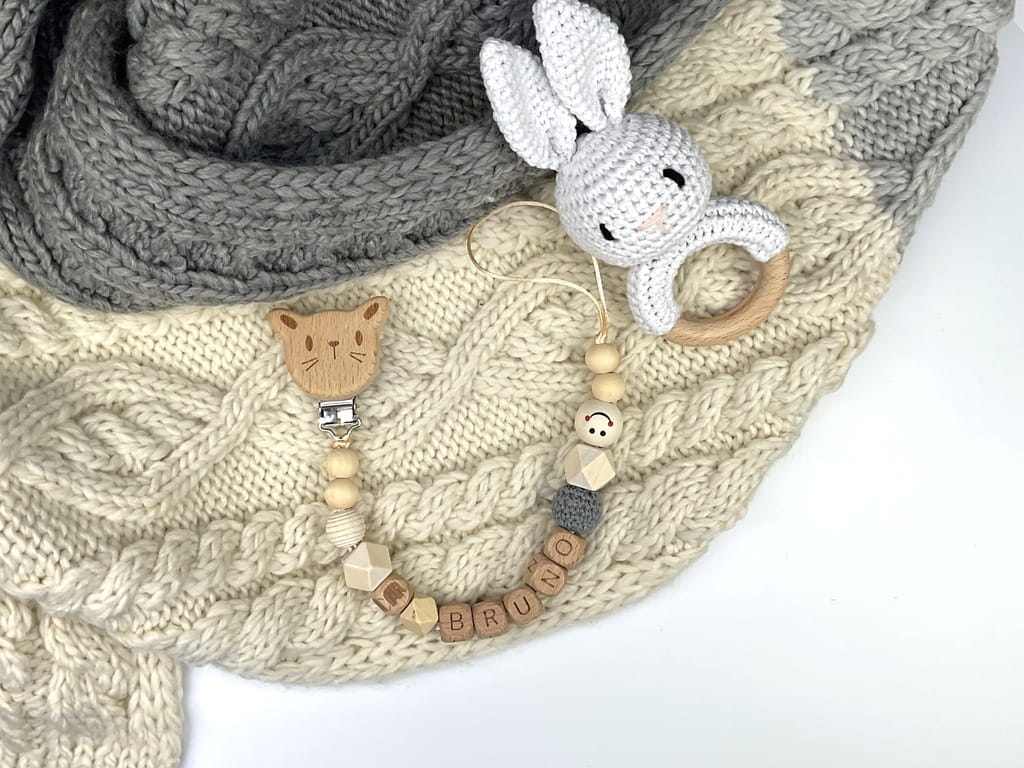 Ręcznie robiona zawieszka do smoczka z imieniem z naturalnego drewna bukowego i świerkowego. Personalizowana, ekologiczna zawieszka z drewnianych koralików, bawełnianej nitki i mocnego sznurka. Idealna na prezent dla dziecka.