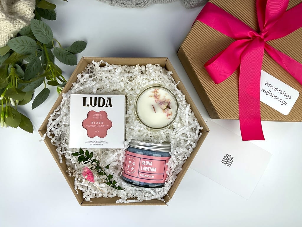 Delikatny zestaw prezentowy dla kobiety – kwiatowa herbata, świeca sojowa i naturalny peeling lawendowy w eleganckim pudełku.
