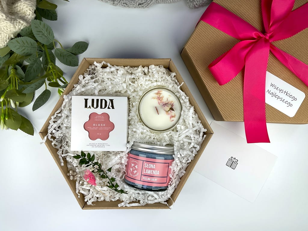 Delikatny zestaw prezentowy dla kobiety – kwiatowa herbata, świeca sojowa i naturalny peeling lawendowy w eleganckim pudełku.
