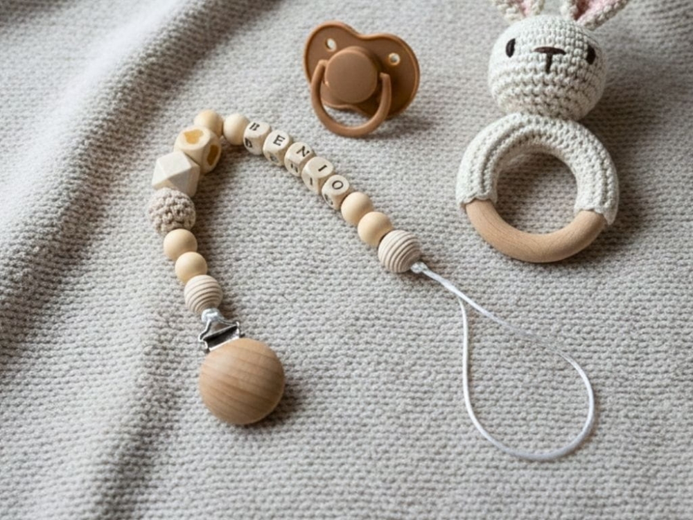 Ręcznie robiona zawieszka do smoczka z imieniem z naturalnego drewna bukowego i świerkowego. Personalizowana, ekologiczna zawieszka z drewnianych koralików, bawełnianej nitki i mocnego sznurka. Idealna na prezent dla dziecka.