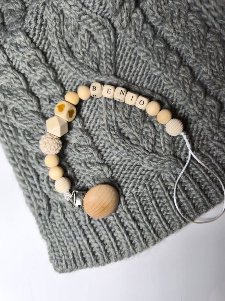 Ręcznie robiona zawieszka do smoczka z imieniem z naturalnego drewna bukowego i świerkowego. Personalizowana, ekologiczna zawieszka z drewnianych koralików, bawełnianej nitki i mocnego sznurka. Idealna na prezent dla dziecka.