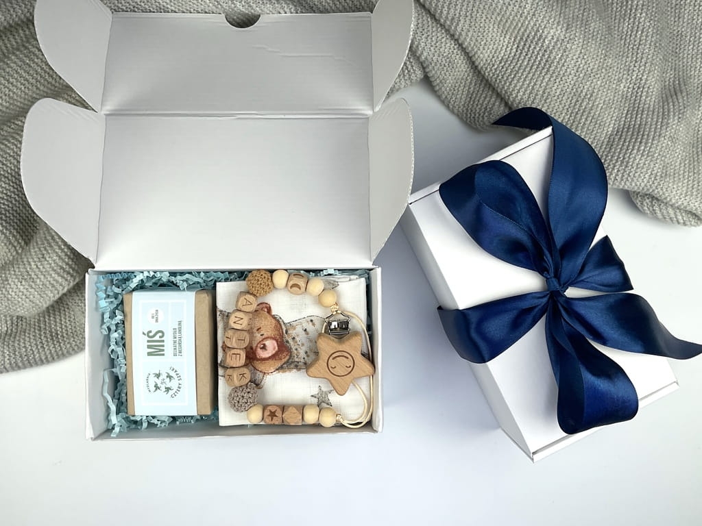 Zestaw prezentowy na chrzest – personalizowana zawieszka do smoczka, muślinowa pieluszka i naturalne mydełko.
