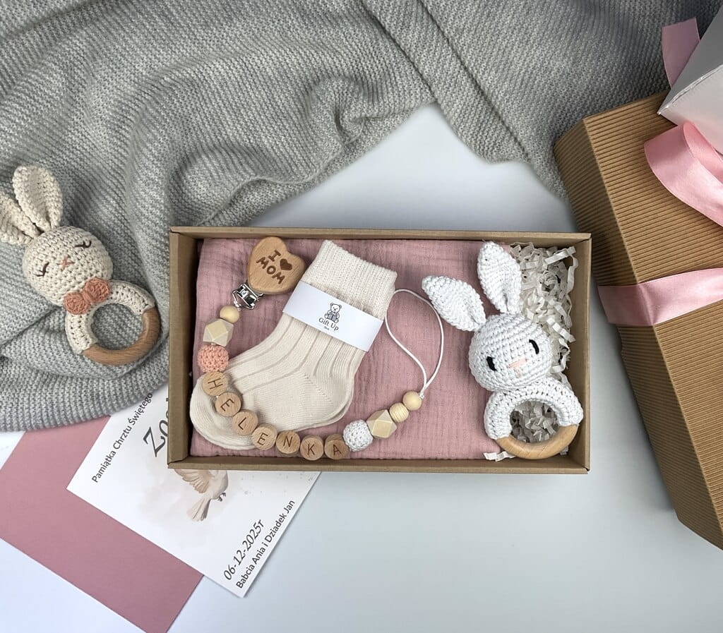 Zestaw prezentowy na chrzest dla chłopca: muślinowa pieluszka, ręcznie robiona grzechotka, zawieszka na smoczek, drewniana zawieszka z imieniem, skarpetki i personalizowana kartka.