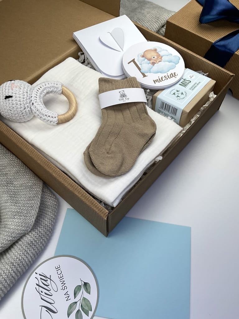 Elegancki box dla niemowlęcia – mydełko naturalne, skarpetki, pieluszka i karty rozwoju dziecka.