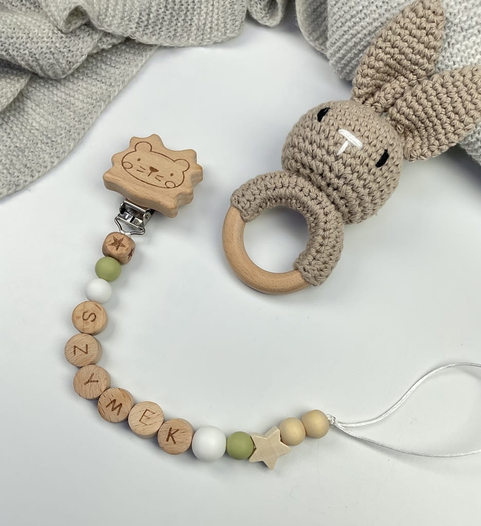 Ręcznie robiona zawieszka do smoczka z drewnianych koralików. Personalizowana imieniem dziecka, bezpieczna i stylowa. Idealny dodatek dla niemowląt i wyjątkowy pomysł na prezent.