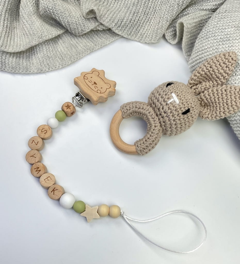 Ręcznie robiona zawieszka do smoczka z drewnianych koralików. Personalizowana imieniem dziecka, bezpieczna i stylowa. Idealny dodatek dla niemowląt i wyjątkowy pomysł na prezent.