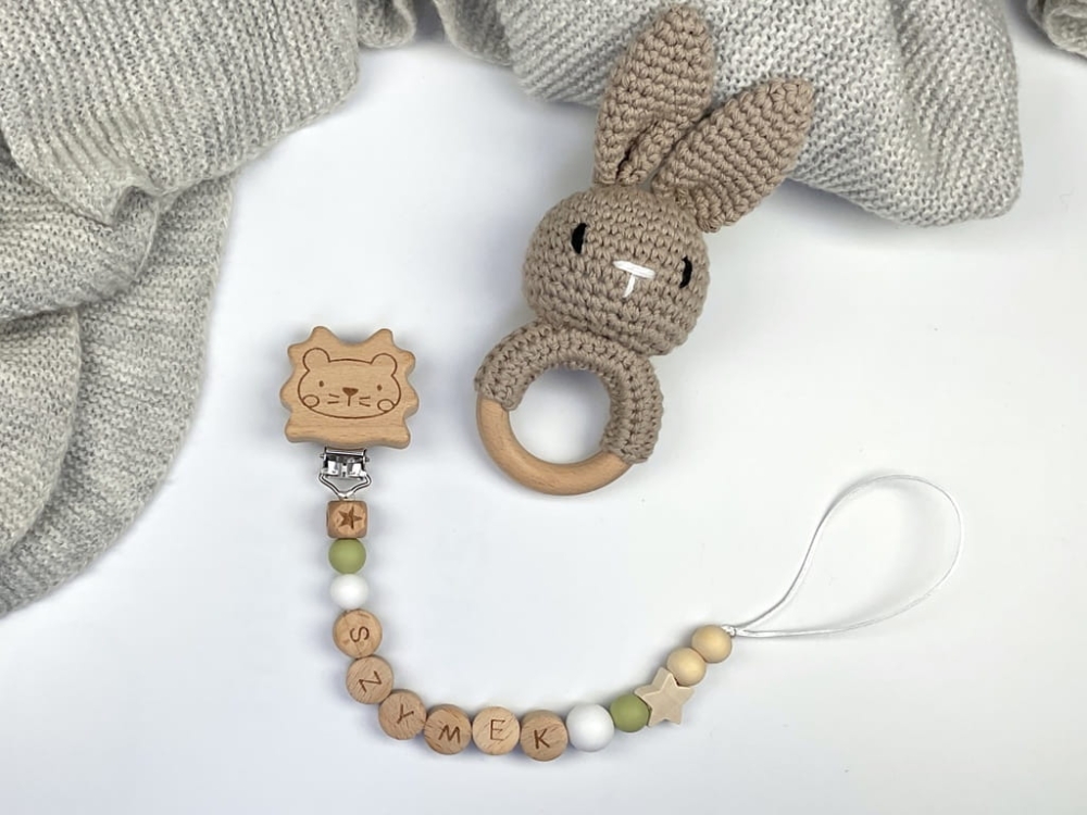 Ręcznie robiona zawieszka do smoczka z drewnianych koralików. Personalizowana imieniem dziecka, bezpieczna i stylowa. Idealny dodatek dla niemowląt i wyjątkowy pomysł na prezent.