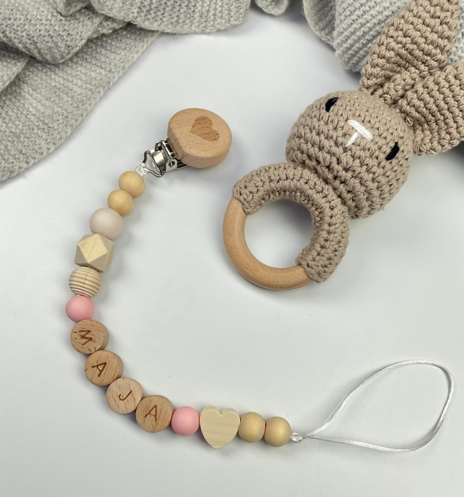 Ręcznie robiona zawieszka do smoczka z drewnianych koralików. Personalizowana imieniem dziecka, bezpieczna i stylowa. Idealny dodatek dla niemowląt i wyjątkowy pomysł na prezent.