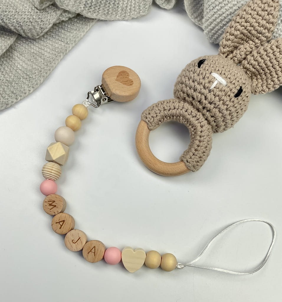 Ręcznie robiona zawieszka do smoczka z drewnianych koralików. Personalizowana imieniem dziecka, bezpieczna i stylowa. Idealny dodatek dla niemowląt i wyjątkowy pomysł na prezent.