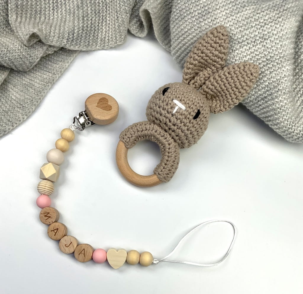 Ręcznie robiona zawieszka do smoczka z drewnianych koralików. Personalizowana imieniem dziecka, bezpieczna i stylowa. Idealny dodatek dla niemowląt i wyjątkowy pomysł na prezent.