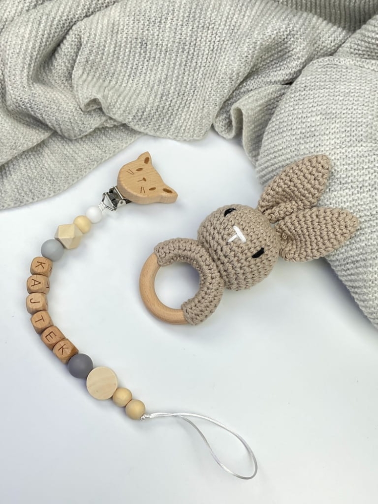Ręcznie robiona zawieszka do smoczka z drewnianych koralików. Personalizowana imieniem dziecka, bezpieczna i stylowa. Idealny dodatek dla niemowląt i wyjątkowy pomysł na prezent.