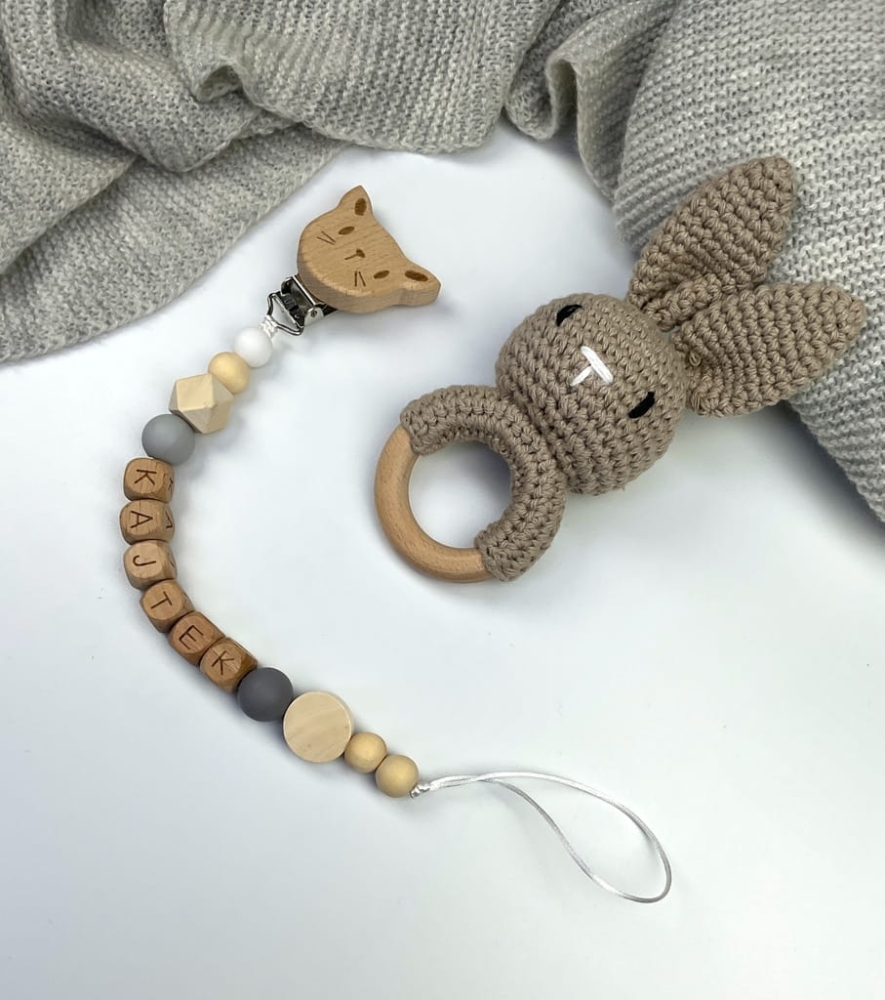 Ręcznie robiona zawieszka do smoczka z drewnianych koralików. Personalizowana imieniem dziecka, bezpieczna i stylowa. Idealny dodatek dla niemowląt i wyjątkowy pomysł na prezent.