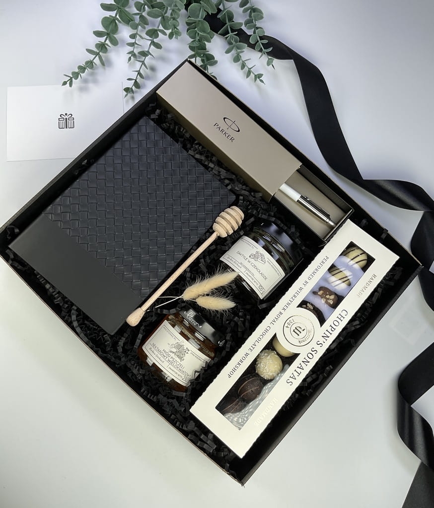 Ekskluzywny box prezentowy łączący klasykę z osłodą. Zawiera kultowy długopis Parker, elegancki notes oraz zestaw smakołyków: praliny, miód i daktyle w czekoladzie. Stylowy prezent gotowy do wręczenia.