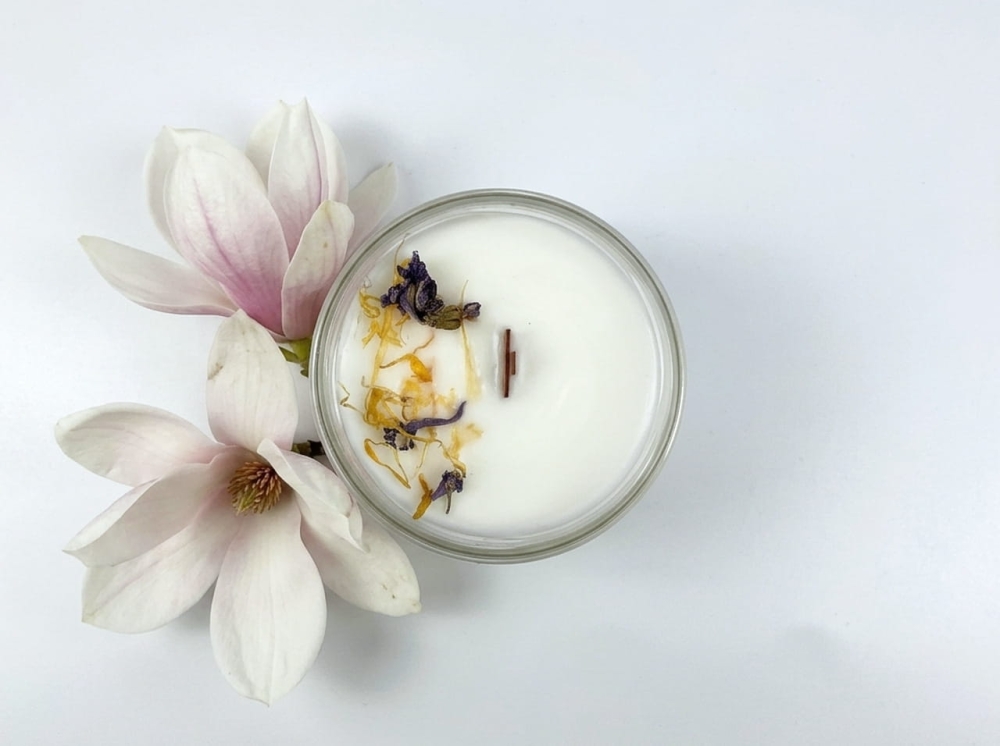 Luksusowa świeca zapachowa Magnolia &amp; Brzoskwinia jako element wystroju nowoczesnego salonu. Jasny, minimalistyczny słoik i naturalny skład. Świeca sojowa, która pali się dłużej i czyściej niż parafina.