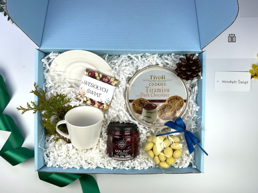 Biała filiżanka porcelanowa w eleganckim boxie prezentowym. Stylowy zestaw upominkowy z malinami w miodzie i słodyczami na wiosnę.