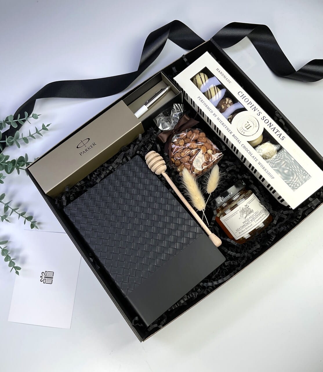 Długopis Parker w etui i elegancki notes w czarnym, ryflowanym pudełku. Prestiżowy upominek biurowy z personalizowaną kokardą.