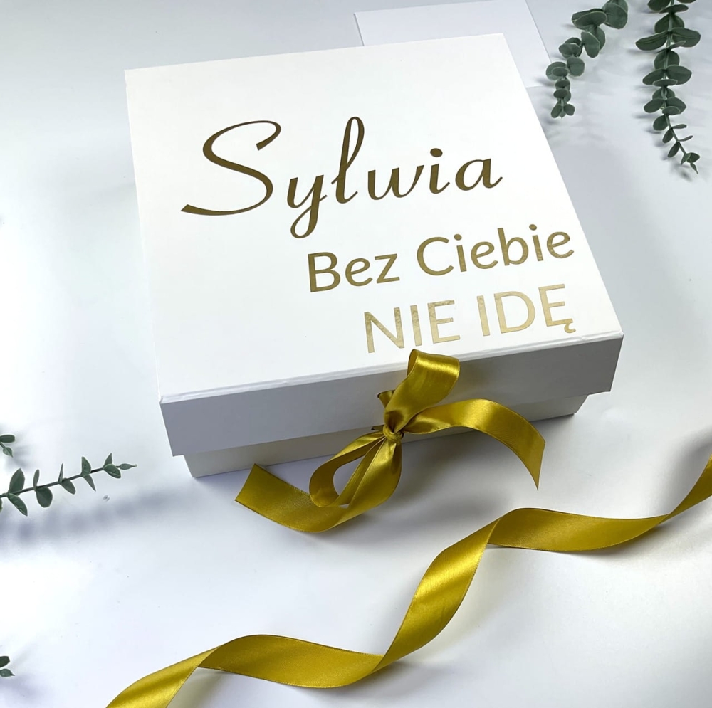 Zestaw prezentowy dla druhny z personalizacją. Białe pudełko, złota wstążka, szampan i kieliszek z imieniem na zamówienie.